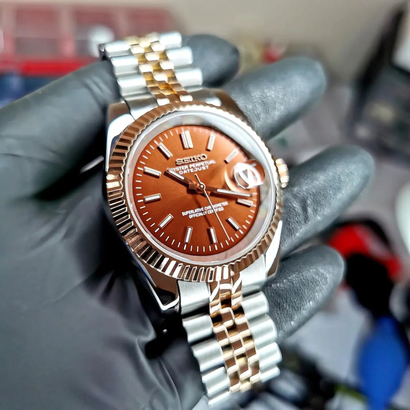 Montre seiko modifiee modele datejust avec un cadran couleur tabac, boitier en acier inoxydable poli et bracelet assorti, alliant elegance et personnalisation unique.