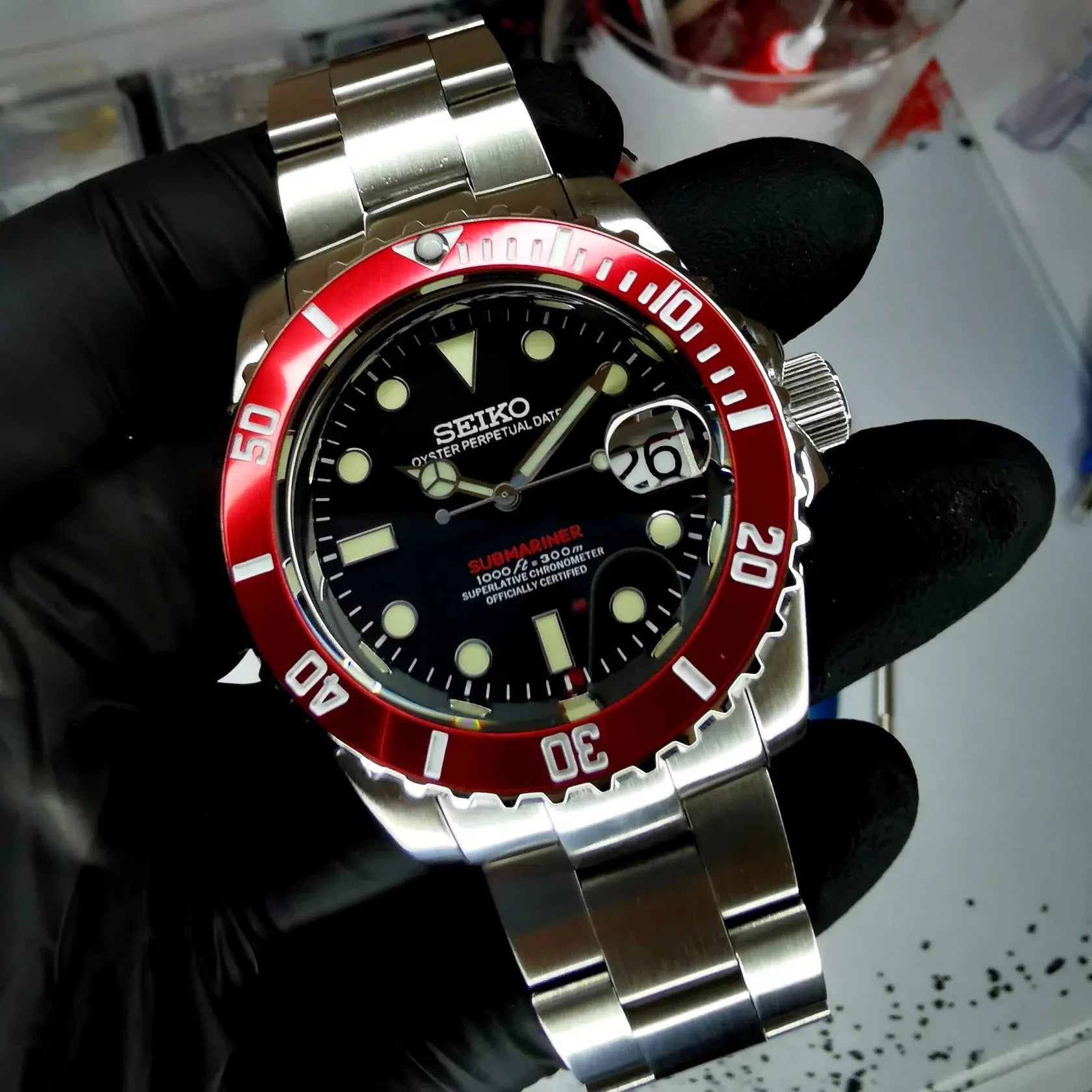Montre Seiko modifiée style Submariner Black & Red, cadran noir avec lunette rouge, étanchéité 300m, design sportif et robuste.
montres automatiques homme seiko, seiko submariner, seiko mod, mod Seiko