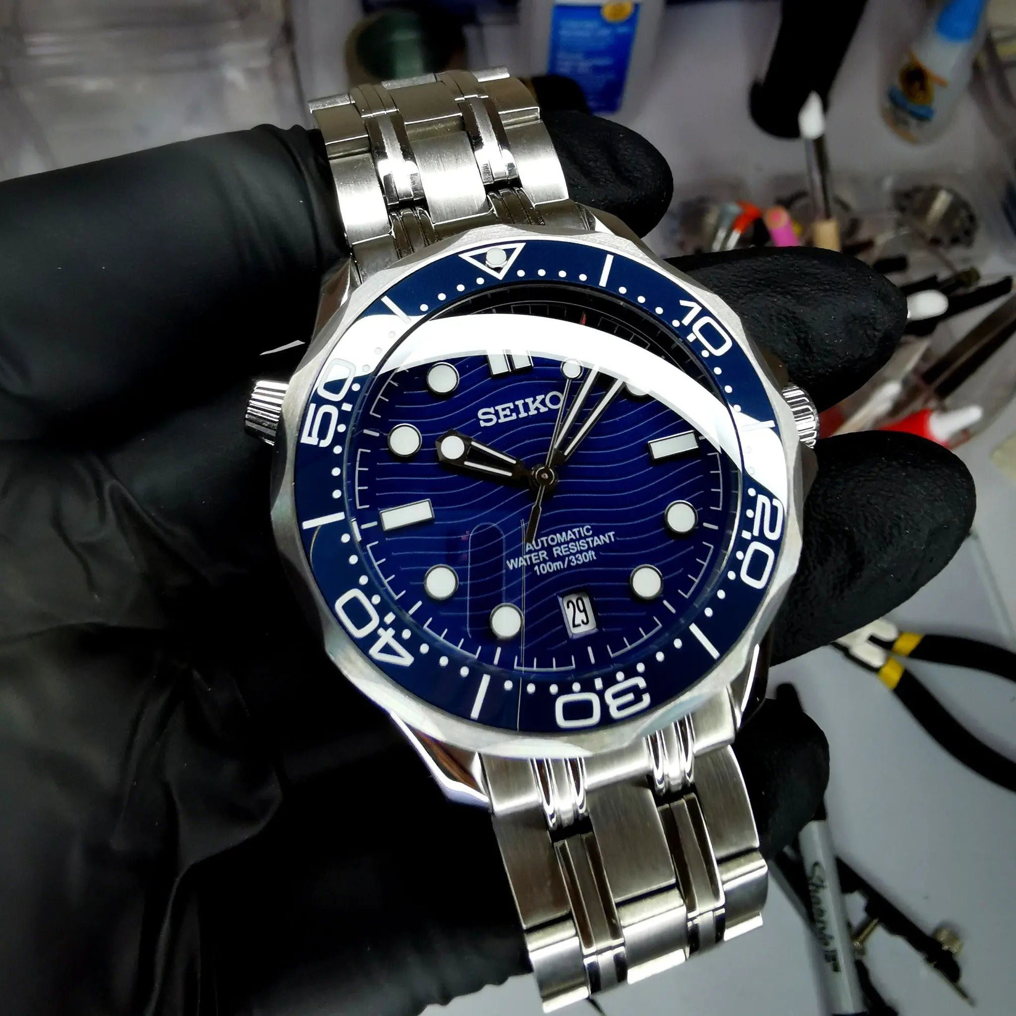 Montre Seiko modifiée style Seamaster 30 ATM, étanchéité 300 mètres, mouvement automatique, design robuste et élégant.
