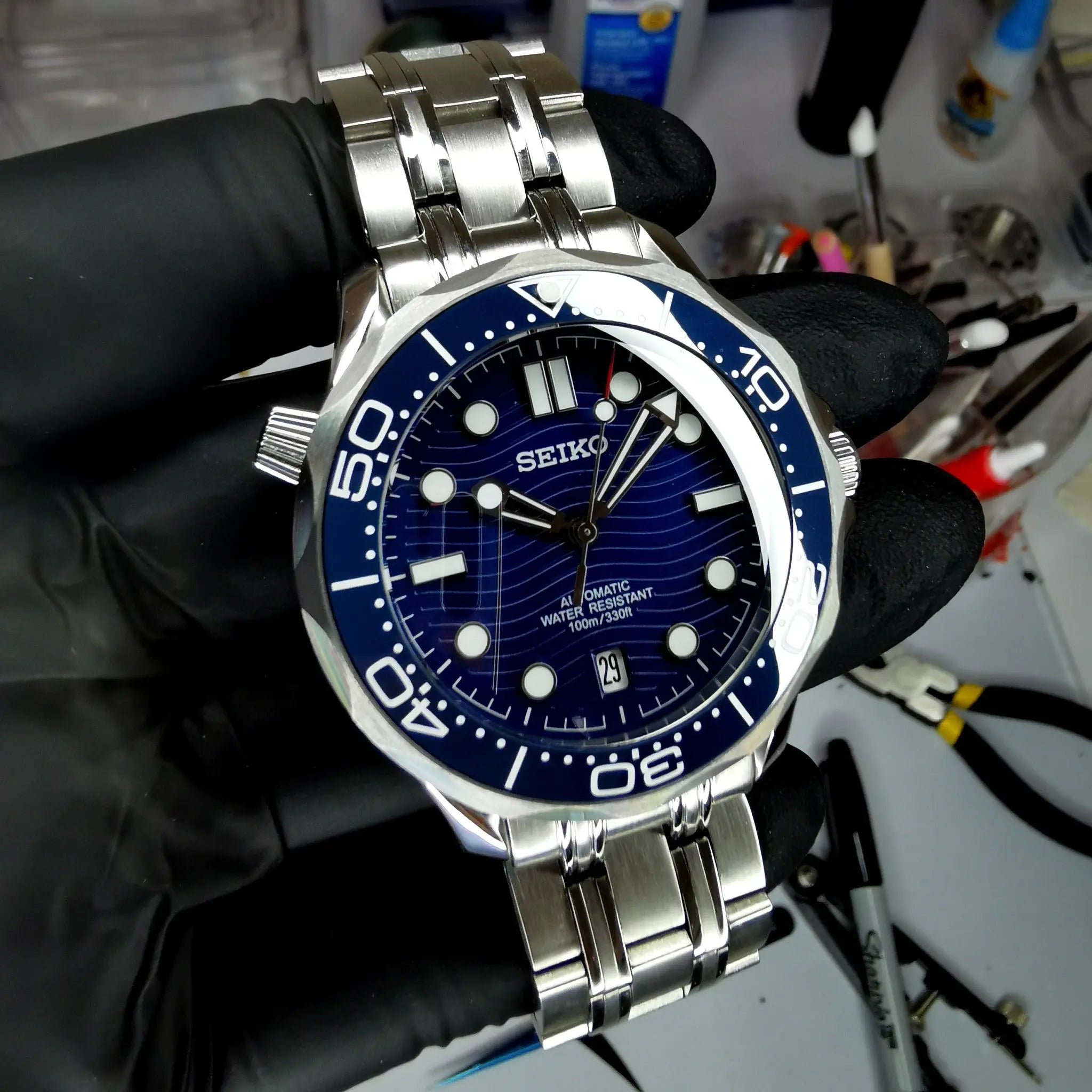 Montre Seiko modifiée style Seamaster 30 ATM, étanchéité 300 mètres, mouvement automatique, design robuste et élégant.