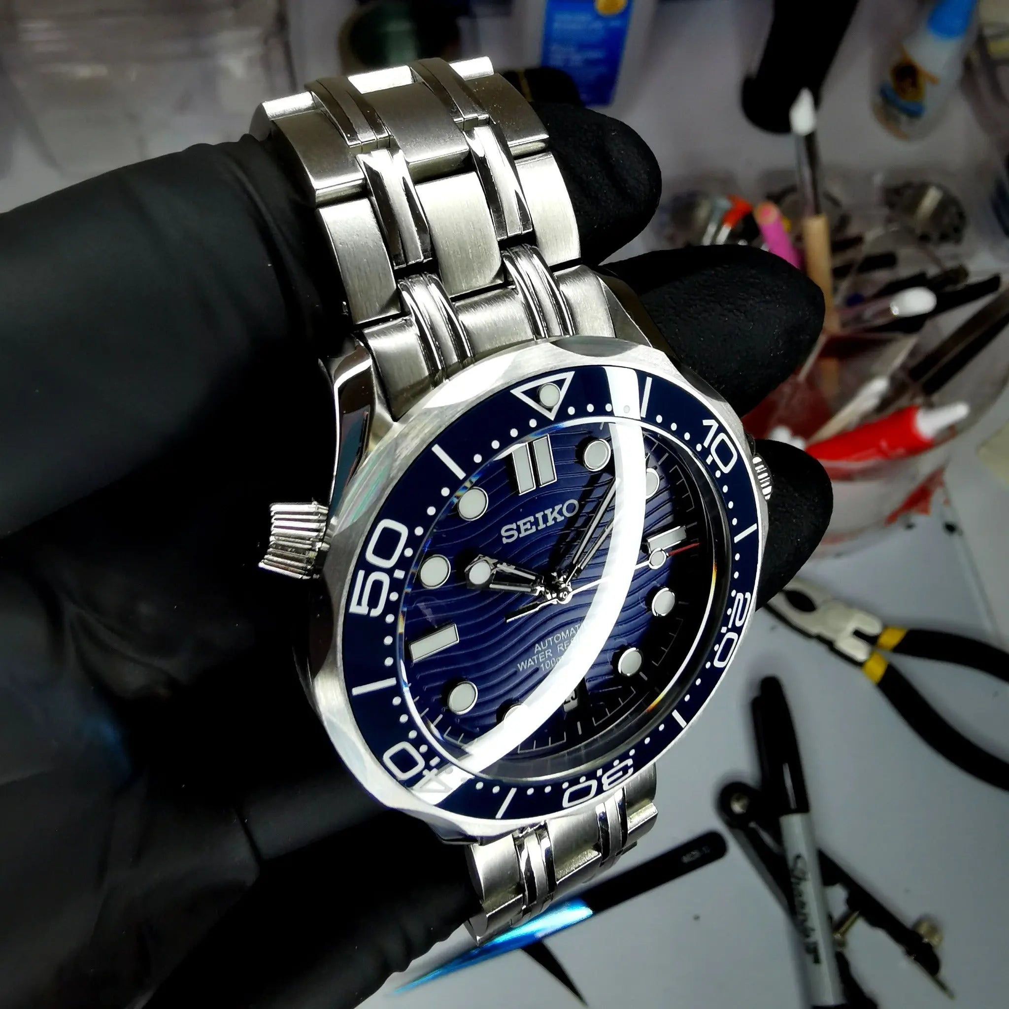 Montre Seiko modifiée style Seamaster 30 ATM, étanchéité 300 mètres, mouvement automatique, design robuste et élégant.
